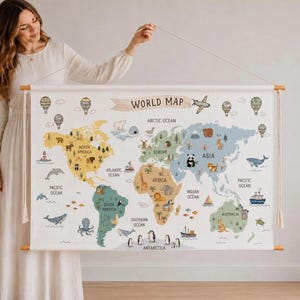 Könnte beinhalten: Ein hängender Wandteppich mit einer Weltkarte und dem Text WORLD MAP am oberen Rand. Die Karte zeigt Kontinente in verschiedenen Farben, verziert mit Illustrationen von Tieren, Schiffen, Flugzeugen und Heißluftballons über den Ozeanen.