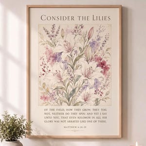 Może przedstawiać: Prostokątny wydruk ścienny z akwarelową ilustracją białych lilii i fioletowych polnych kwiatów. Tekst brzmi: Consider the Lilies of the field, how they grow; they toil not, neither do they spin: and yet I say unto you, that even Solomon in all his glory was not arrayed like one of these. Matthew 6:28-29. Rama nie jest dołączona. Tylko wydruk.