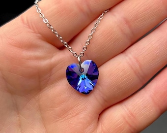May include: A silver chain necklace with a blue crystal heart pendant.