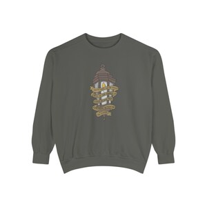 May include: A dark gray sweatshirt featuring a lantern graphic with the text "Happiness can be found even in the darkest of times if one only remembers to turn on the light." The lantern is brown and yellow.