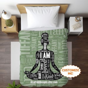 May include: A green and white bedspread featuring a silhouette of a person in a yoga pose, filled with positive affirmations like "I AM Loved" and "Strong." The words "Tiffany" and "Customize Me!" are also visible.