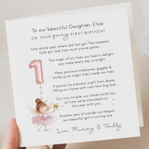 May include: A white birthday card with a poem and illustration. The card is addressed to Elsie and celebrates her first birthday. A pink number one balloon and a fairy are illustrated on the card.