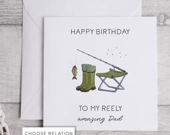 May include: A white birthday card with a fishing illustration. The design includes a fishing rod, a caught fish, green wellington boots, and a folding chair. The card's text reads "HAPPY BIRTHDAY" and "TO MY REELY amazing Dad."