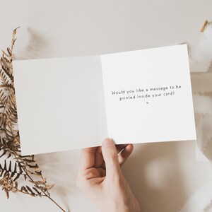 May include: A white card with the text "Would you like a message to be printed inside your card?" on the inside.