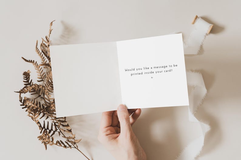 May include: A white card with the text "Would you like a message to be printed inside your card?" on the inside.