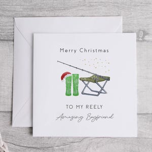 May include: A white Christmas card with a green fishing boot, a fishing rod, and a folding chair. The card says "Merry Christmas to my Reely Amazing Boyfriend".