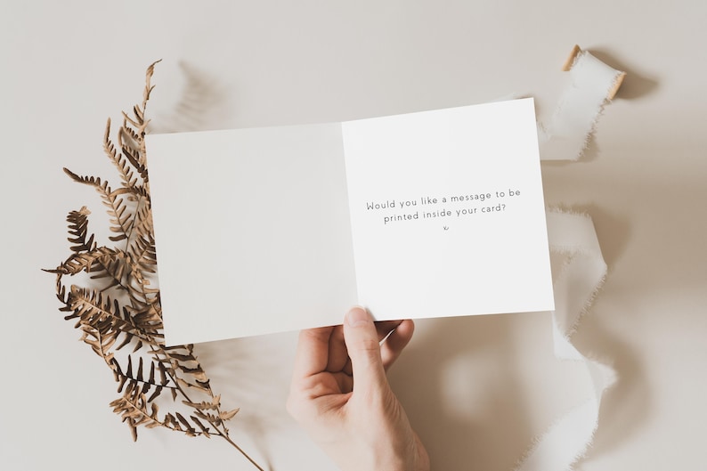 May include: A white card with the text "Would you like a message to be printed inside your card?" on the inside.