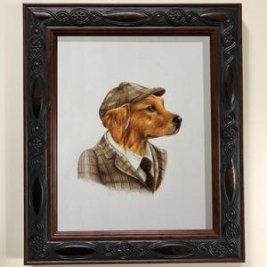 May include: A framed portrait of a golden retriever wearing a tweed suit, tie, and cap. The dog is depicted in profile, set against a white background. The frame is dark brown with decorative detailing.