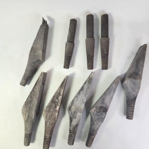 Könnte beinhalten: Eine Sammlung von zehn verwitterten Holzobjekten. Die Objekte haben eine Vielzahl von Formen, darunter spitze und zylindrische Formen. Jedes Stück hat einen Gewindesockel. Das Holz hat ein graues, gealtertes Aussehen.