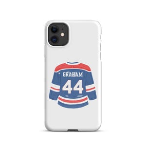Könnte beinhalten: Eine weiße Smartphone-Hülle mit einer grafischen Illustration eines blau-rot-weißen Eishockeytrikots auf der Rückseite. Das Trikot zeigt den Namen GRAHAM in weißen Blockbuchstaben über der Nummer 44, zentriert auf der Rückseite des Kleidungsstücks.