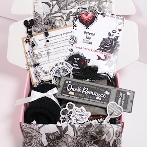 Blind Date with a Kindle gift set styled with cocoa, tea, cozy socks, themed bookmark, drink coaster, and sweet treat beside a kindle paperwhite. Includes kindle insert for clear case, kindle charm keychain, and dust plug charm. Perfect for readers decorating their kindle case, kindle sleeve, or ereader case with kindle stickers, kindle decorations, and aesthetic kindle accessories designed for cozy reading nights.