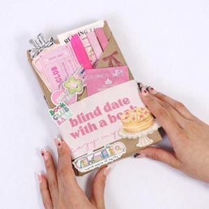 Kindle mystery box displayed as blind date with an ebook and blind date with a book kindle concept, featuring digital book bundle presentation, book gift box styling, bookish bundles arrangement, and reader gifts appeal for modern book lovers.
