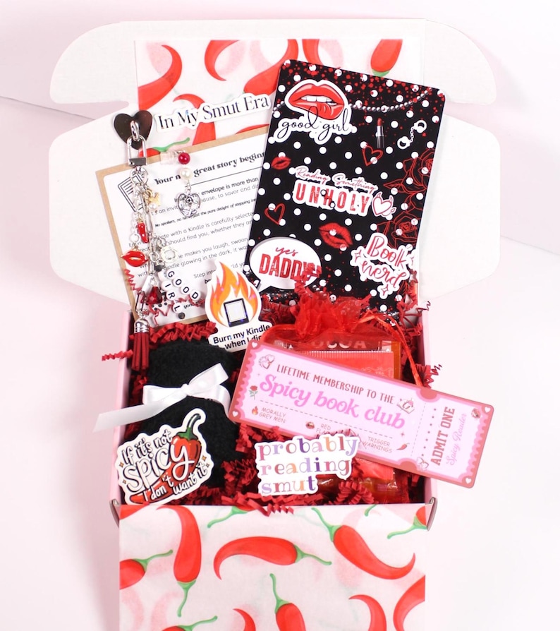 Blind Date with a Kindle. Decorative kindle insert placed inside a clear kindle case with hanging kindle charm keychain and dust plug charm attached to the charging port. Styled with kindle stickers and cozy accessories, this kindle mystery box gift is designed for readers who enjoy customizing their kindle paperwhite, kindle oasis, or kindle scribe with aesthetic kindle inserts, kindle skins, and personalized kindle decorations.