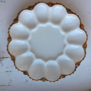 May include: White ceramic egg plate with a gold rim and 12 individual indentations for serving eggs.
