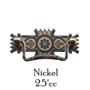 May include: Nickel cabinet pull with a decorative design featuring three circles with floral patterns. The pull is 2.5 inches in center-to-center measurement.