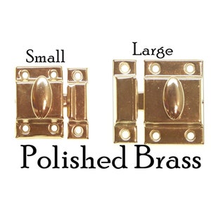 May include: Two polished brass cabinet door catches, one small and one large.  The catches have a rounded knob and are designed to be mounted on a door or cabinet.