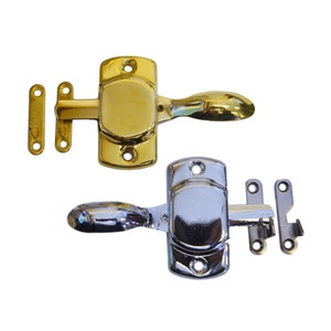May include: Two metal latches, one gold-toned and one silver-toned, are displayed against a white background. Each latch has a handle and two small mounting plates. The gold latch is on top, and the silver latch is below.