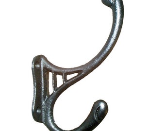 May include: A silver cast iron hook with a decorative design. The hook has a curved shape and a rounded end.
