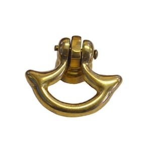 May include: A gold-toned metal cabinet pull with a curved, half-moon shape. The pull has a decorative, raised design on the edges.