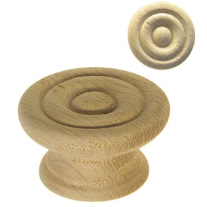 May include: A wooden knob with a circular top featuring a concentric circle design. The knob is light brown in color and has a smooth, polished finish.