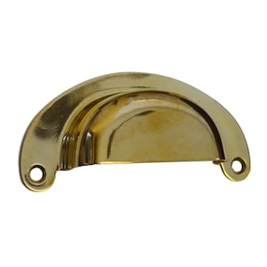 May include: A shiny, gold-colored, half-moon shaped drawer pull. The hardware has a curved design with two small holes on either end for mounting. The pull is made of metal and has a reflective surface.