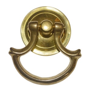 May include: A brass cabinet pull with a ring handle and a round decorative plate.
