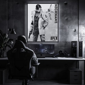 May include: A black and white illustration of a video game character from Apex Legends. The character is wearing a jacket and holding a gun. The image is framed and hanging on a wall in a dark room. The text "NICKNAME" and "APEX LEGENDS" is visible on the image.