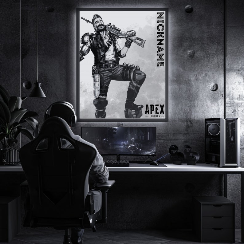 May include: A black and white illustration of a video game character from Apex Legends. The character is standing with a weapon in their hand. The image is framed and hanging on a wall in a dark room. The text "NICKNAME" and "APEX LEGENDS" is visible on the image.