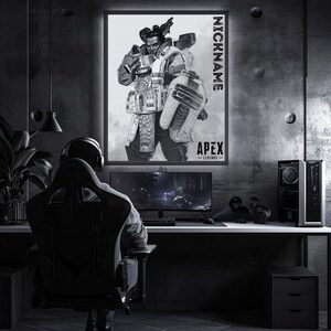 May include: A black and white illustration of a video game character from Apex Legends. The character is holding a gun and has a serious expression on their face. The image is framed and hanging on a wall in a dark room. The text "NICKNAME" and "APEX LEGENDS" is visible on the image.