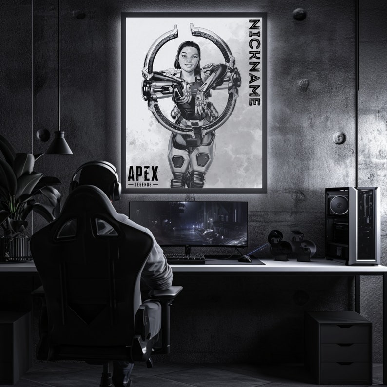 May include: A black and white illustration of a female video game character from Apex Legends. The character is holding a gun and is standing in front of a circle. The text "NICKNAME" is written vertically on the right side of the image. The text "APEX LEGENDS" is written at the bottom of the image.