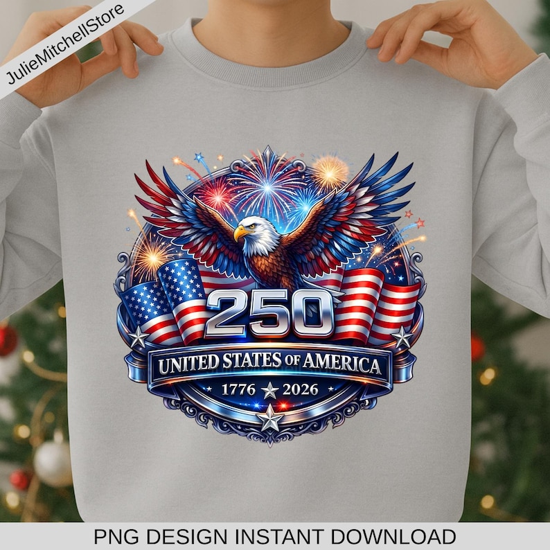 Pode incluir: Camisola cinza claro com um design patri&oacute;tico. O gr&aacute;fico inclui uma &aacute;guia careca, bandeiras americanas, fogos de artif&iacute;cio e o texto "250 UNITED STATES OF AMERICA 1776 2026".
