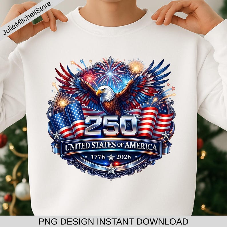 Pode incluir: Camisola branca com um design patri&oacute;tico. Apresenta uma &aacute;guia, bandeiras americanas e fogos de artif&iacute;cio. O design inclui o texto "250 UNITED STATES OF AMERICA 1776-2026". O design &eacute; em vermelho, branco e azul.