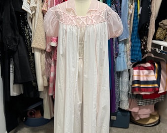 May include: A white and pink vintage nightgown with lace detailing. The nightgown is on a dress form and has a long, flowing skirt.