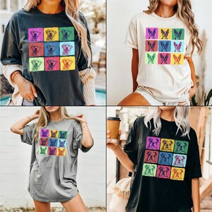 May include: Four different t-shirts with a pop art design featuring various dog breeds. The shirts are in black, gray, white, and dark gray.