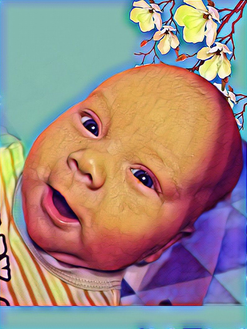 May include: A close-up of a baby's face with a bright, happy expression. The baby is wearing a striped shirt and has a flower crown on their head.
