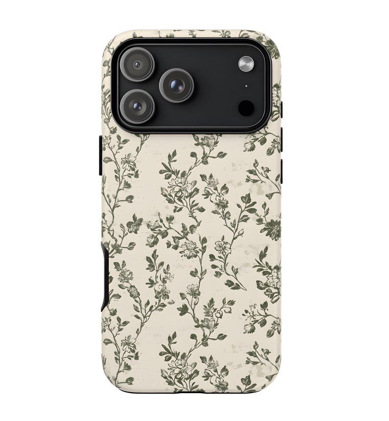 Puede incluir: Funda de tel&eacute;fono con dise&ntilde;o floral. La funda tiene un fondo color crema con un patr&oacute;n de flores y enredaderas verdes y blancas. El &aacute;rea de la c&aacute;mara es negra.