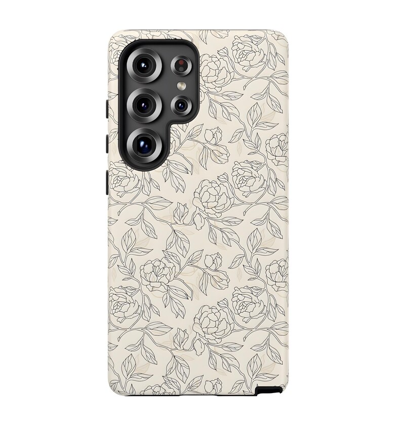 May include: A phone case with a floral design. The case features a cream-colored background with a pattern of black line-drawn flowers and leaves. The phone's camera lenses are visible at the top.