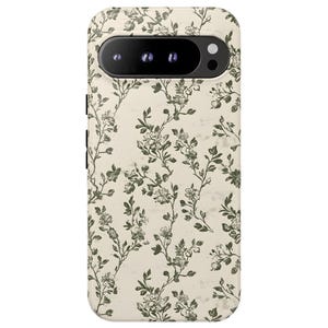 Puede incluir: Una funda de tel&eacute;fono con un estampado floral. La funda tiene un fondo color crema con un patr&oacute;n repetido de vides y flores florales verdes. El &aacute;rea de la c&aacute;mara es negra.