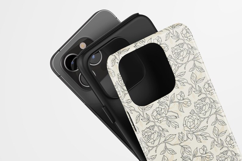 May include: Three phone cases stacked together. The top case is white with a black floral design. The middle case is black, and the bottom case is gray. The cases are angled towards the viewer.