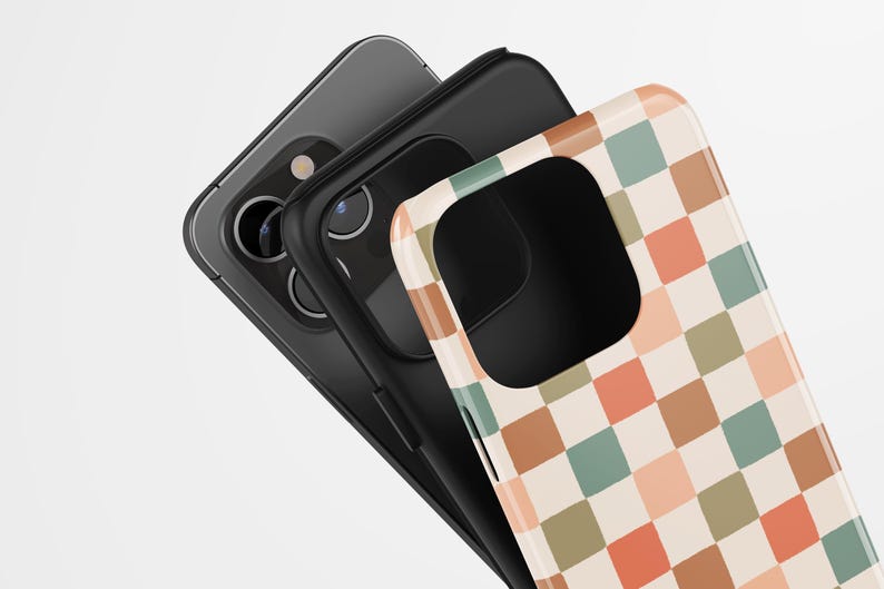 May include: Three smartphone cases. The top case has a retro checkerboard pattern in peach, green, and brown squares. The middle case is black, and the bottom case is gray. The cases are stacked at an angle.
