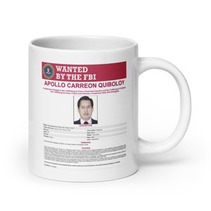 May include: White ceramic mug with a red and white wanted poster design. The poster features a photo of a man with the text "WANTED BY THE FBI APOLLO CARREON QUIBOLOY" and a description of the charges against him.