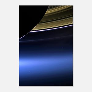 May include: A high-contrast space photograph showing a curved segment of a planet with a deep blue atmosphere and a bright horizon line. Above the planet, a portion of golden-brown planetary rings arcs across a solid black background.