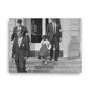 May include: Black and white photograph of a young girl in a white dress and black shoes walking down a set of stairs. Two men in suits and hats are walking behind her.