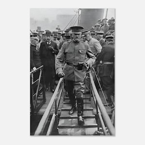 May include: A black and white photograph showing a military officer in a high-collared uniform, peaked cap, and tall boots walking down a gangplank. The officer carries a sword at the hip, surrounded by other uniformed personnel on a ship deck.
