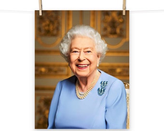 May include: A portrait of Queen Elizabeth II wearing a light blue dress with a pearl necklace and a blue brooch. She is smiling and looking directly at the camera. The background is a gold and white patterned wall.