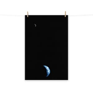 Puede incluir: Una fotografía de la Tierra tomada desde el espacio, que muestra una vista en forma de media luna del planeta sobre un fondo negro. La imagen captura los tonos azules y blancos de la Tierra, con una fina luna creciente visible en la esquina superior izquierda.