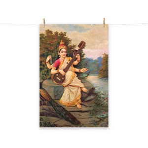 May include: A painting of a woman playing a sitar, sitting on a rock with a peacock beside her. The woman is wearing a white and gold sari and a red and gold blouse. The background is a lush green landscape with a river.