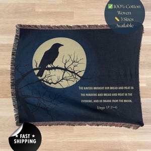 Puede incluir: Manta tejida azul oscuro con un cuervo frente a la luna llena. El texto cita Reyes 17:2-6. Hecha de 100% algodón. Disponible en 3 tamaños.
