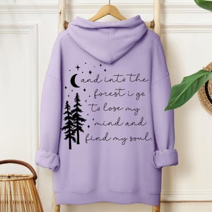 Cozy nature-inspired hoodie featuring a forest quote, perfect for hiking, camping, or outdoor adventures. A great gift for women who love inspirational clothing and nature-inspired designs with moon and star details.