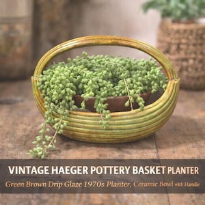 May include: A vintage Haeger pottery basket planter with a green and brown drip glaze. The ceramic bowl with a handle is filled with green, cascading plants. The planter is from the 1970s. Text on the image reads: VINTAGE HAEGER POTTERY BASKET PLANTER, Green Brown Drip Glaze 1970s Planter, Ceramic Bowl with Handle.